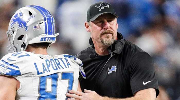 Lions coach Dan Campbell, right, pats the back of tight end Sam LaPorta as he walks off the field.